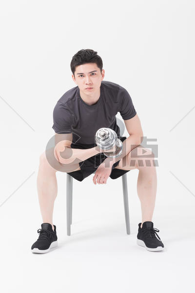 青年男性坐椅子上举哑铃健身图片素材免费下载