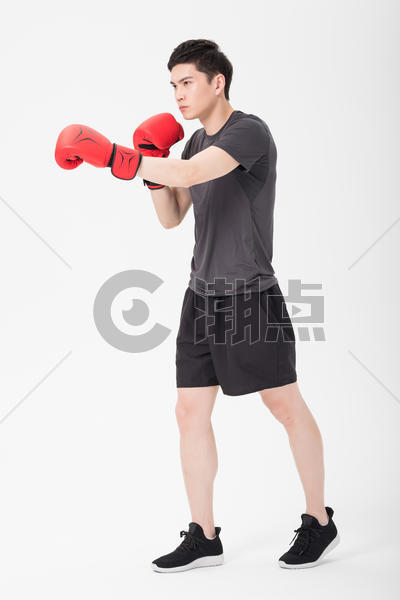 健身男性戴拳击手套打拳出拳图片素材免费下载