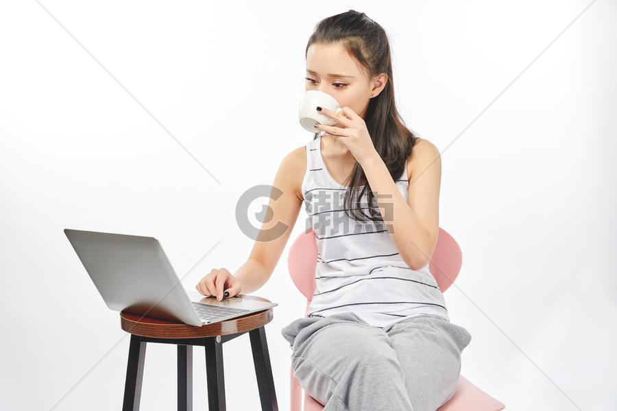 青年女性喝着开飞使用电脑办公图片素材免费下载