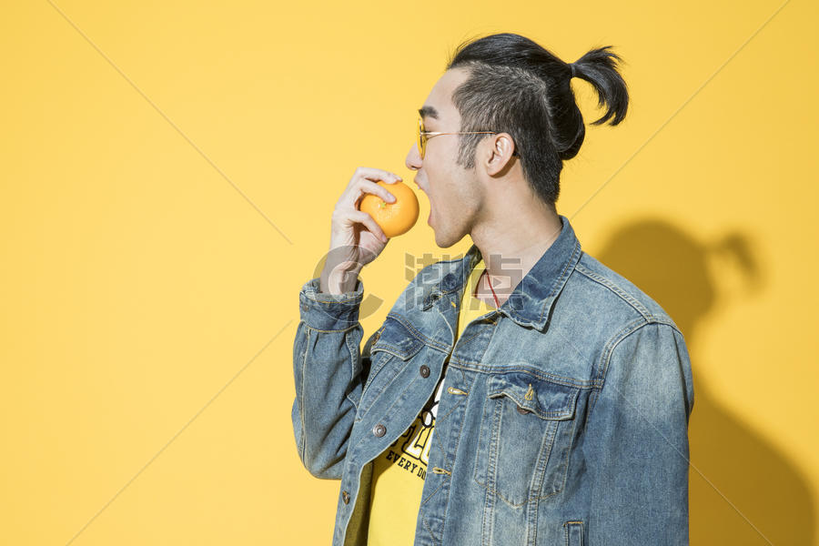 拿着橘子的青年男性图片素材免费下载
