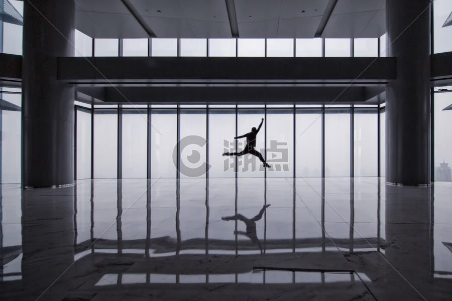 落地玻璃前跳跃的男子剪影图片素材免费下载