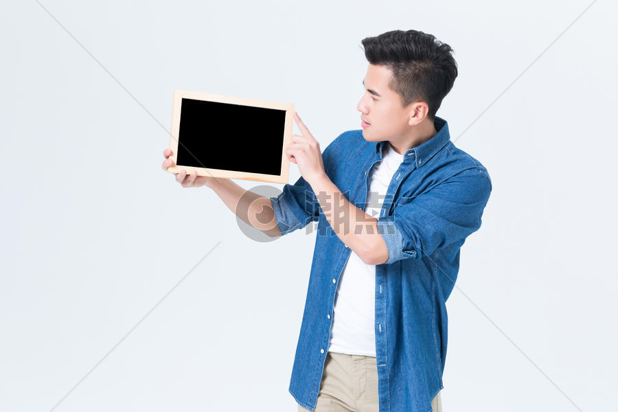 年轻男性手拿空白小黑板展示图片素材免费下载