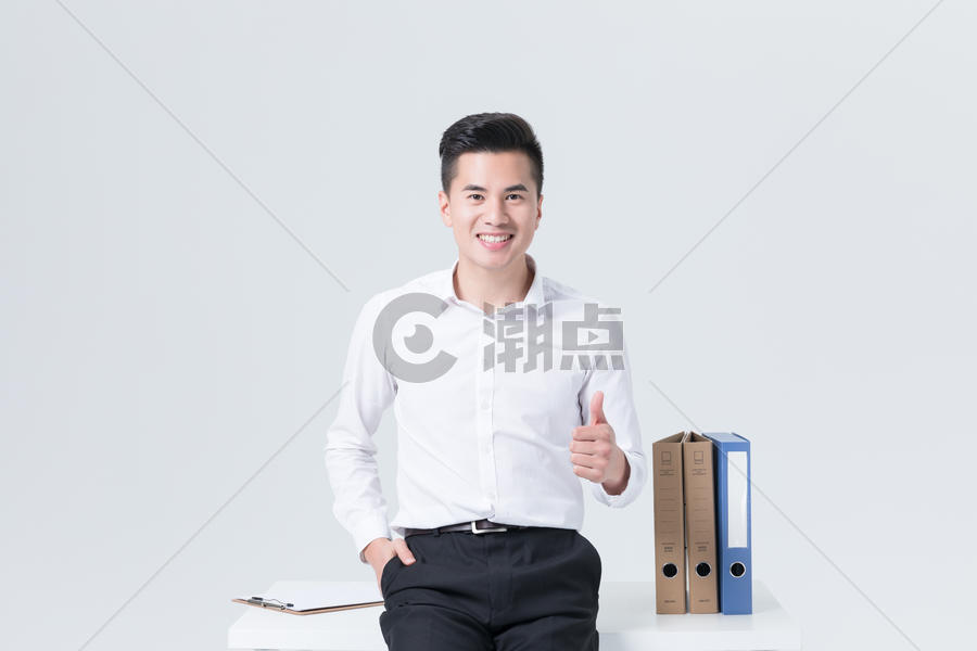 坐在办公桌上自信微笑的商务男士图片素材免费下载