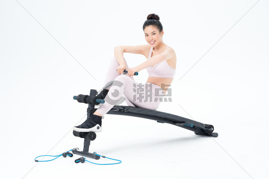坐在仰卧板上锻炼的运动女性图片素材免费下载