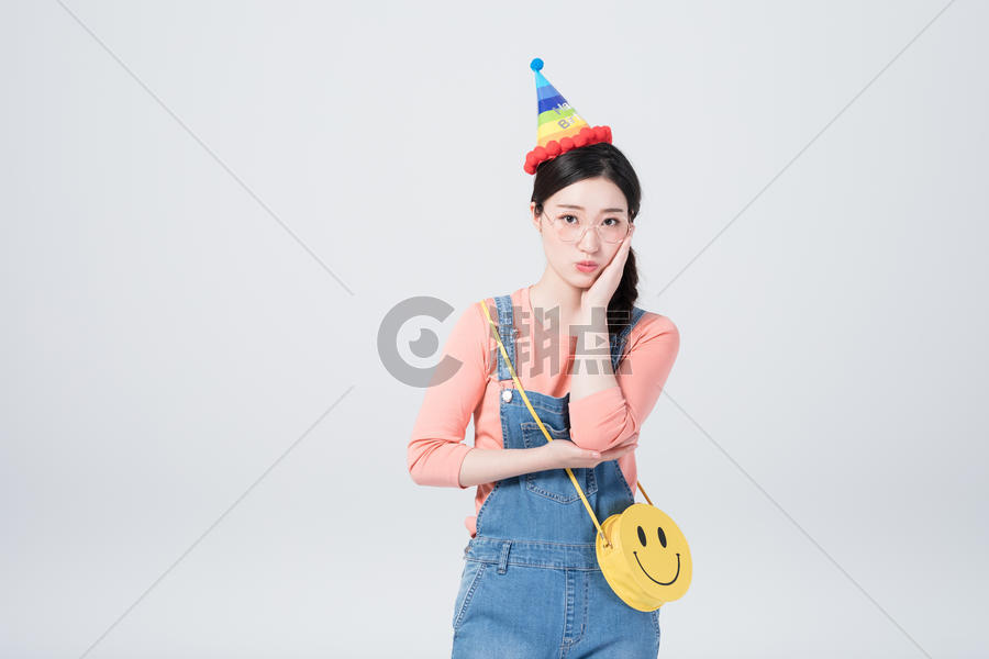 戴着生日帽微笑庆祝的青年女性图片素材免费下载