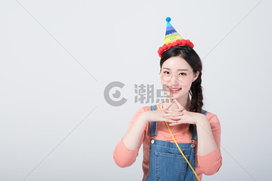 戴着生日帽微笑庆祝的青年女性图片素材免费下载