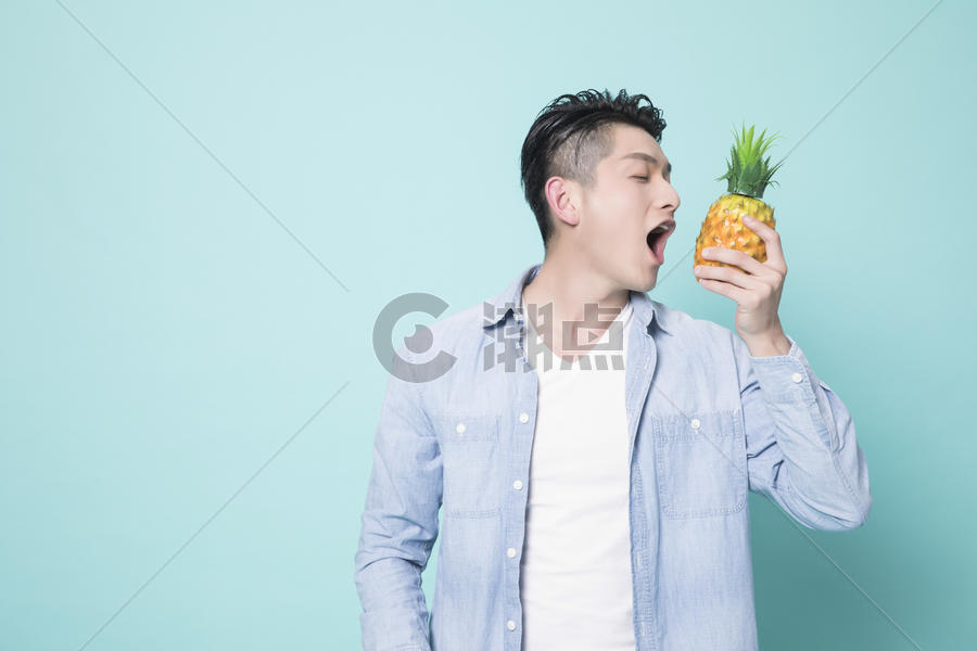 拿着菠萝的青年男性图片素材免费下载