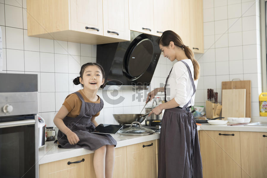 妈妈和女儿在新家厨房烧菜图片素材免费下载