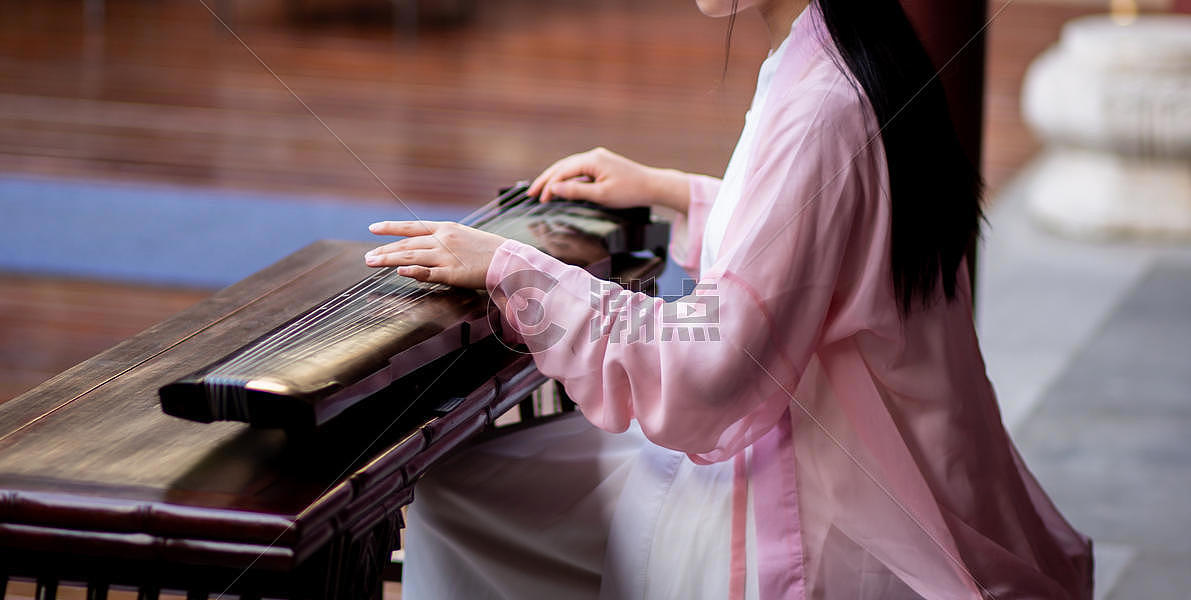 穿中国传统服饰的女性弹奏古琴图片素材免费下载