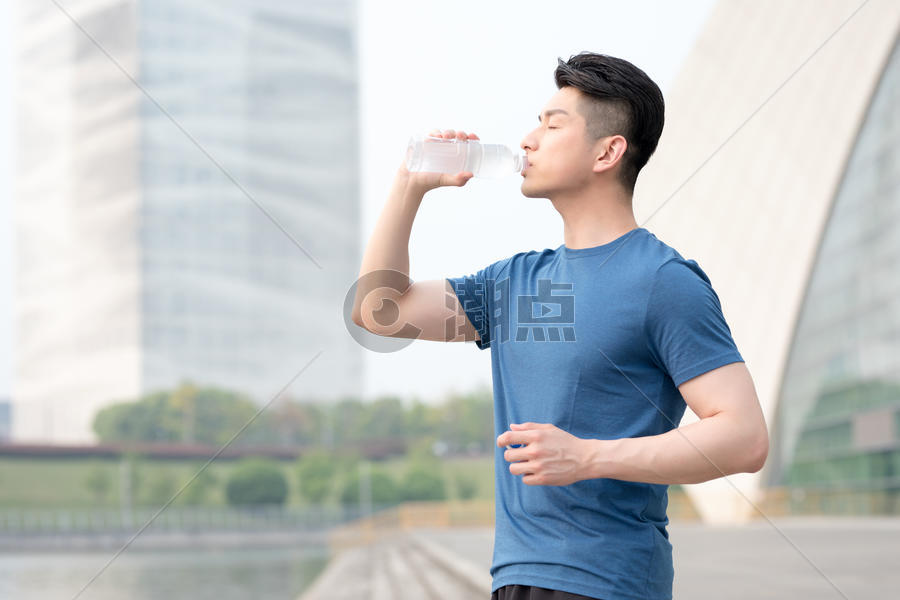 运动健身后站着喝水的年轻男性图片素材免费下载