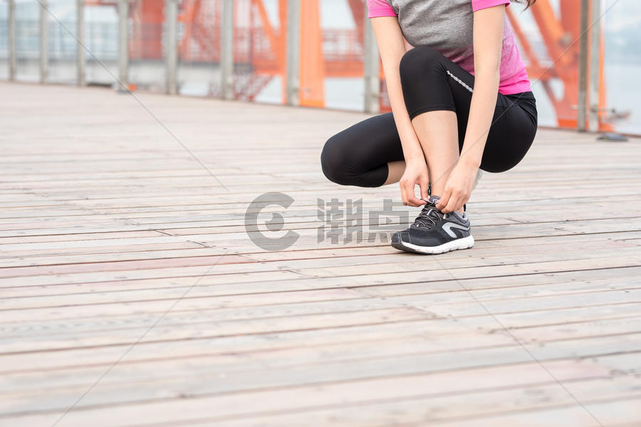 户外运动女性蹲下系鞋带图片素材免费下载
