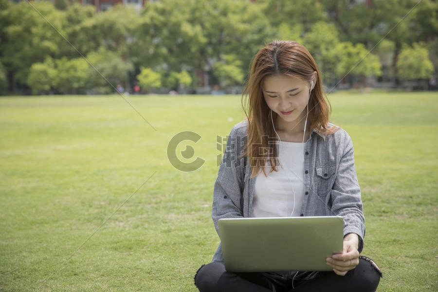 女学生在大学草坪上学习图片素材免费下载