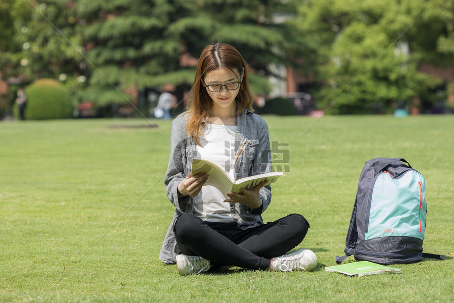女学生在大学草坪上看书图片素材免费下载