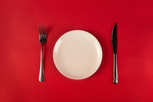 红色背景上的刀叉与盘子图片素材免费下载