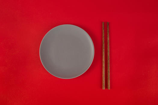 红色背景上的筷子与盘子图片素材免费下载