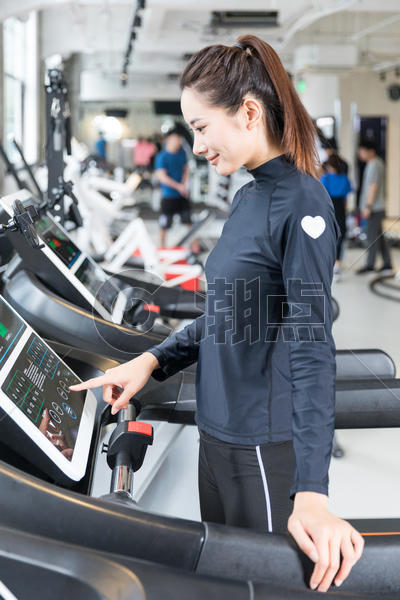 年轻女性健身房使用跑步机跑步图片素材免费下载