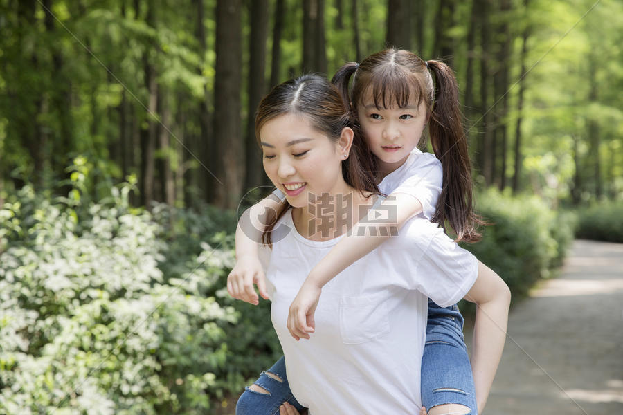 妈妈背着女儿在公园走路图片素材免费下载