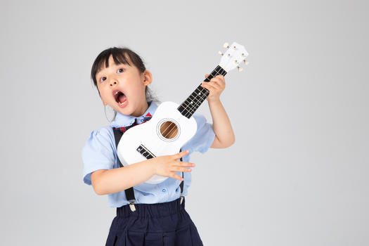 弹尤克里里高声唱歌的小女孩图片素材免费下载