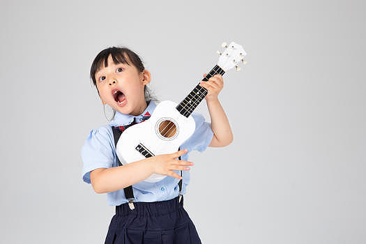 弹尤克里里高声唱歌的小女孩图片素材免费下载