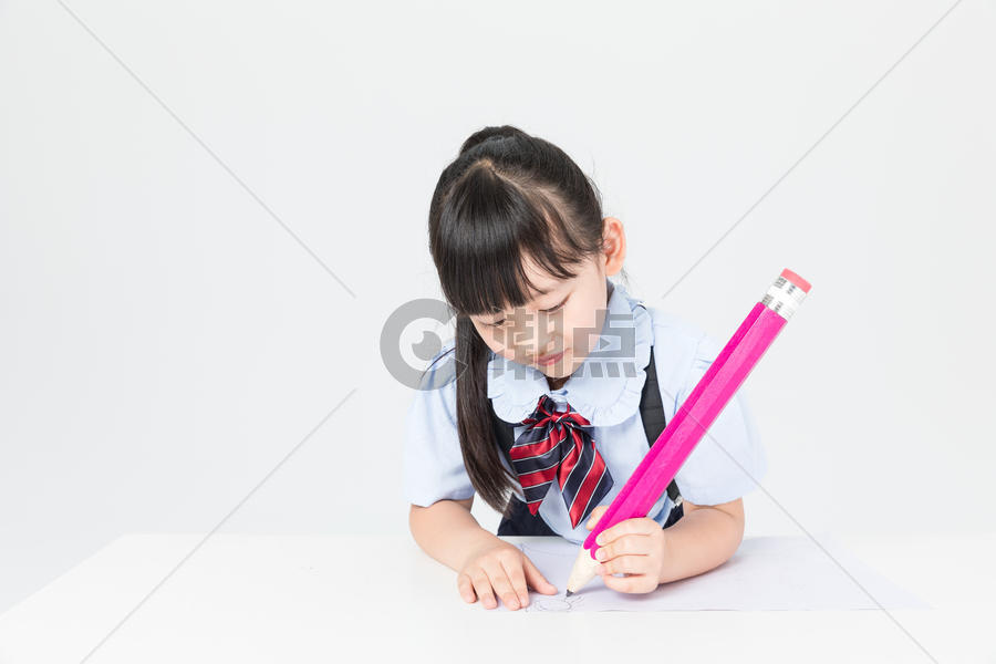 拿着铅笔写字的小女孩图片素材免费下载