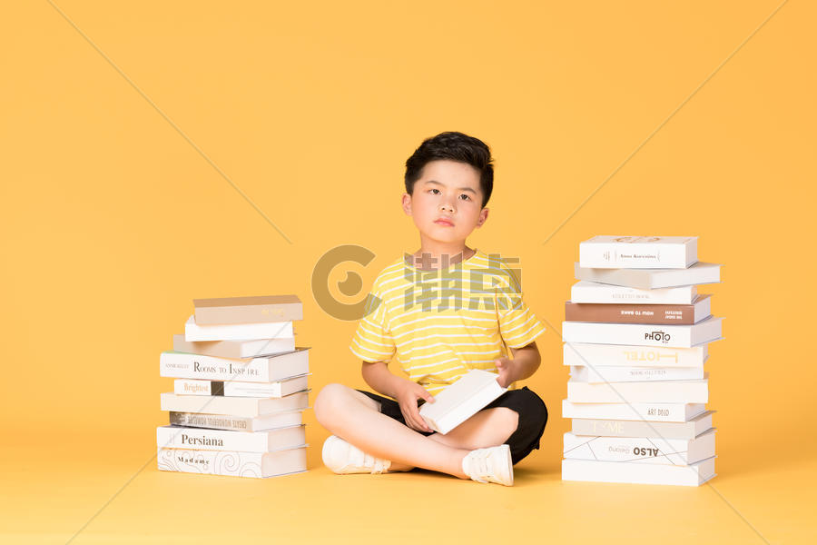 坐在书堆旁边思考的儿童小朋友图片素材免费下载