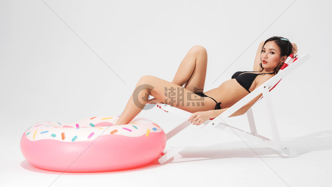 泳装美女坐在沙滩椅上与泳圈图片素材免费下载