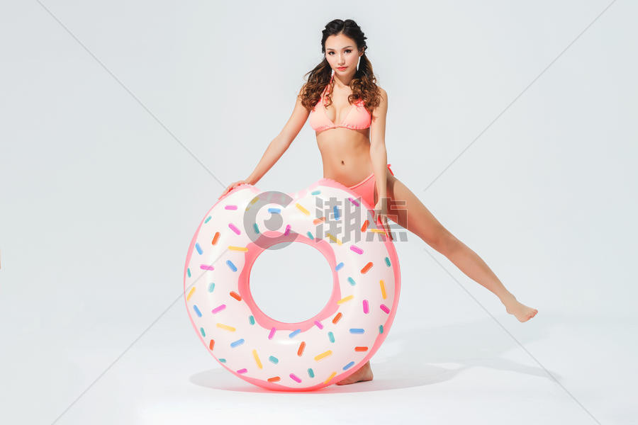 穿粉色比基尼的可爱女生拿着甜甜圈泳圈图片素材免费下载