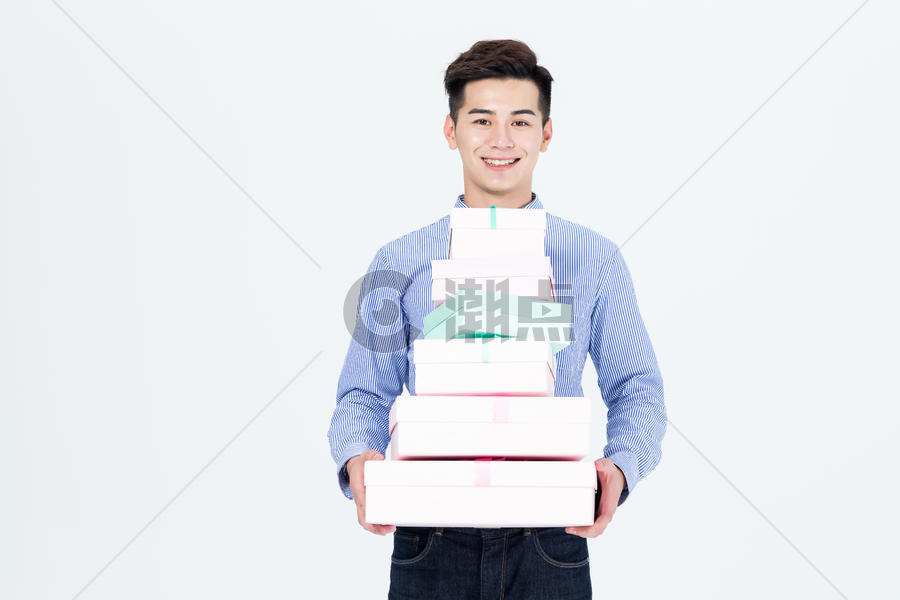 年轻男性抱着一推礼物盒图片素材免费下载