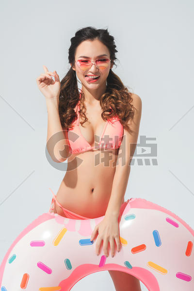 穿粉色比基尼的可爱女生拿着泳圈图片素材免费下载