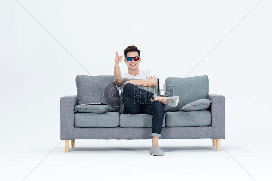 青年男性坐在沙发上看3D电影图片素材免费下载