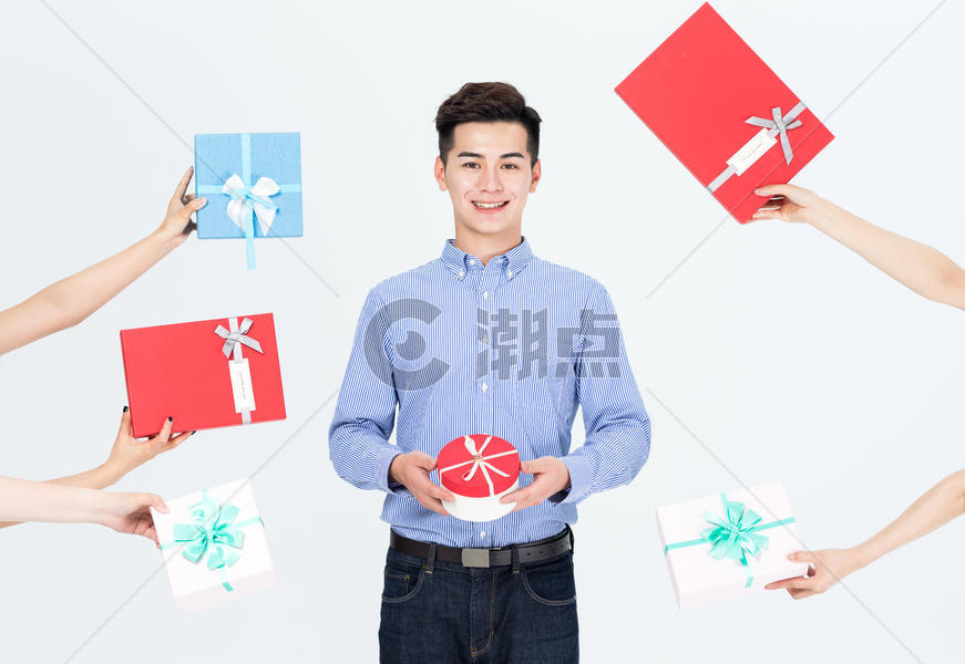 年轻男性抱着一推礼物盒图片素材免费下载