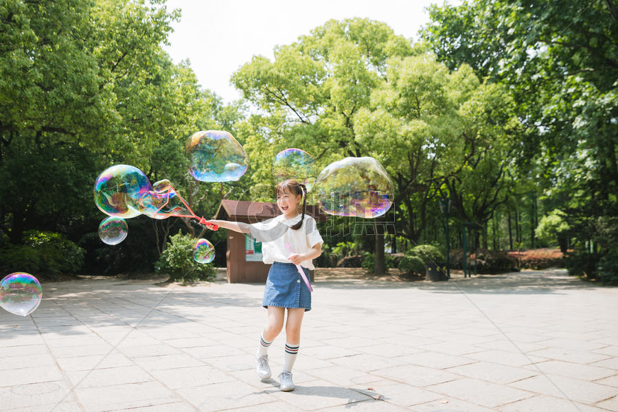 公园里可爱女孩玩吹泡泡图片素材免费下载