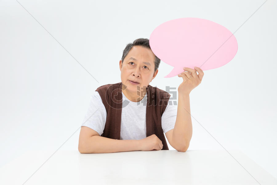 手拿粉色对话气泡框的老年人图片素材免费下载