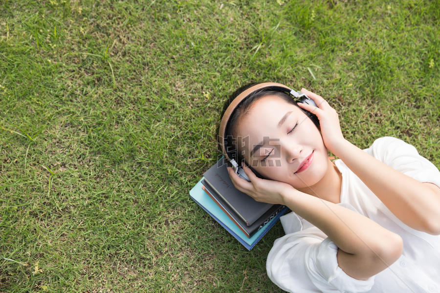 青春学生躺草地上听音乐图片素材免费下载