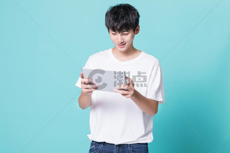 青年男性玩平板电脑图片素材免费下载
