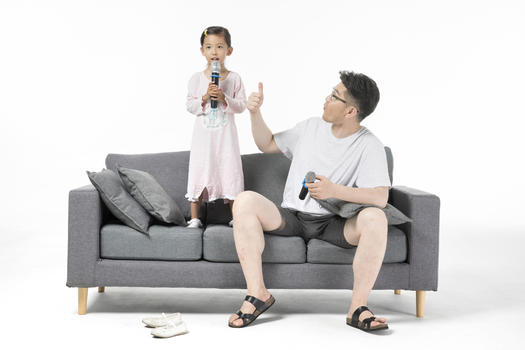 爸爸和女儿在沙发上唱歌图片素材免费下载