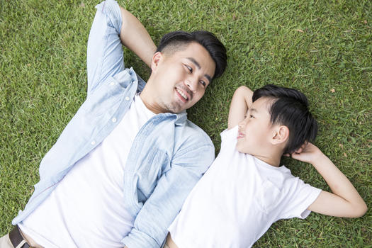 父子躺在公园草地上休息图片素材免费下载