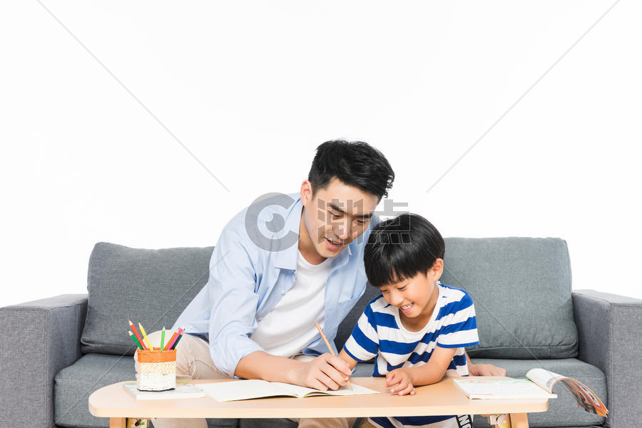 沙发上父亲辅导孩子写作业图片素材免费下载