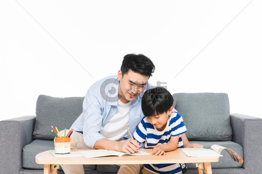 沙发上父亲辅导孩子写作业图片素材免费下载