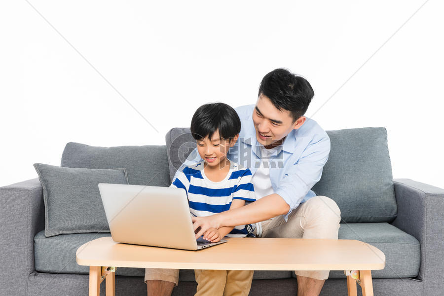 沙发上父亲指导孩子用电脑图片素材免费下载