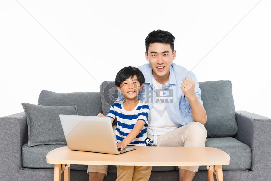 沙发上父亲指导孩子用电脑图片素材免费下载