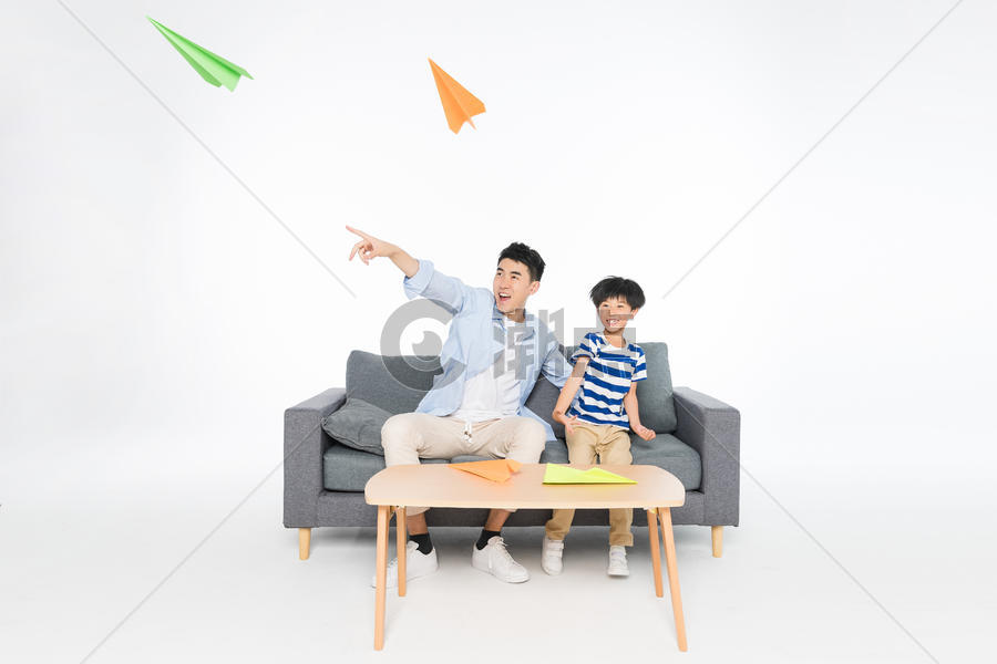 沙发上父子玩纸飞机图片素材免费下载