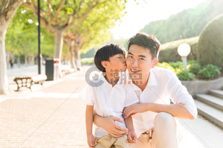 父亲节公园里孩子亲吻父亲图片素材免费下载