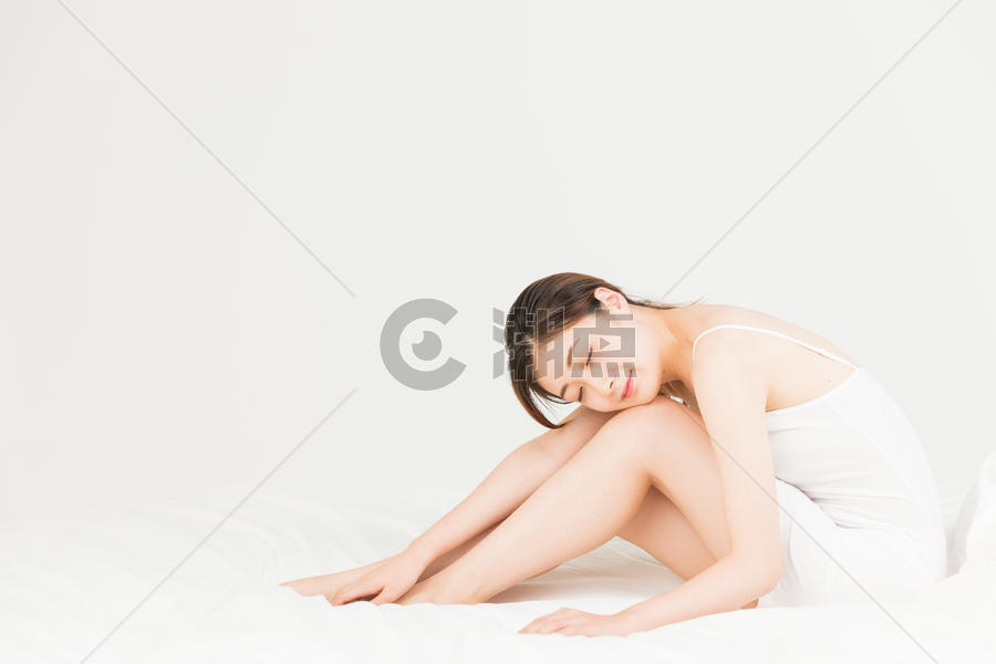 年轻女性坐床上休息图片素材免费下载
