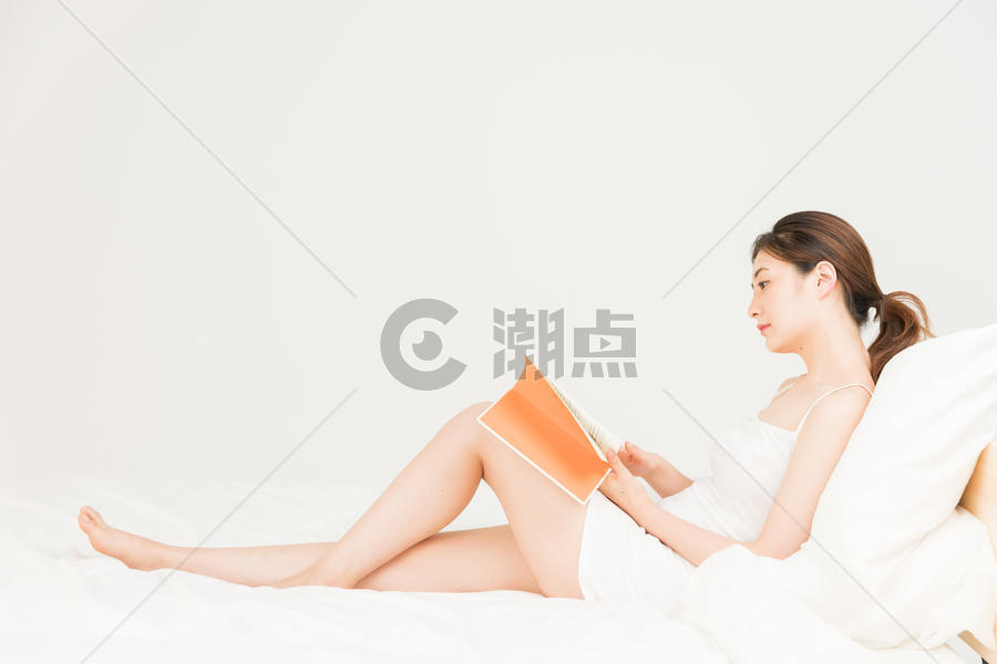 年轻女性床上看书图片素材免费下载