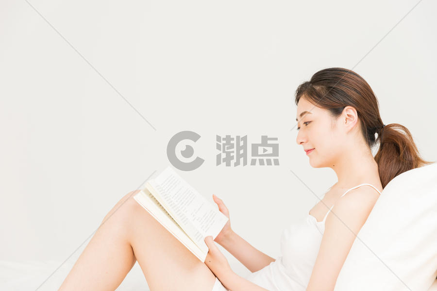 年轻女性床上看书图片素材免费下载