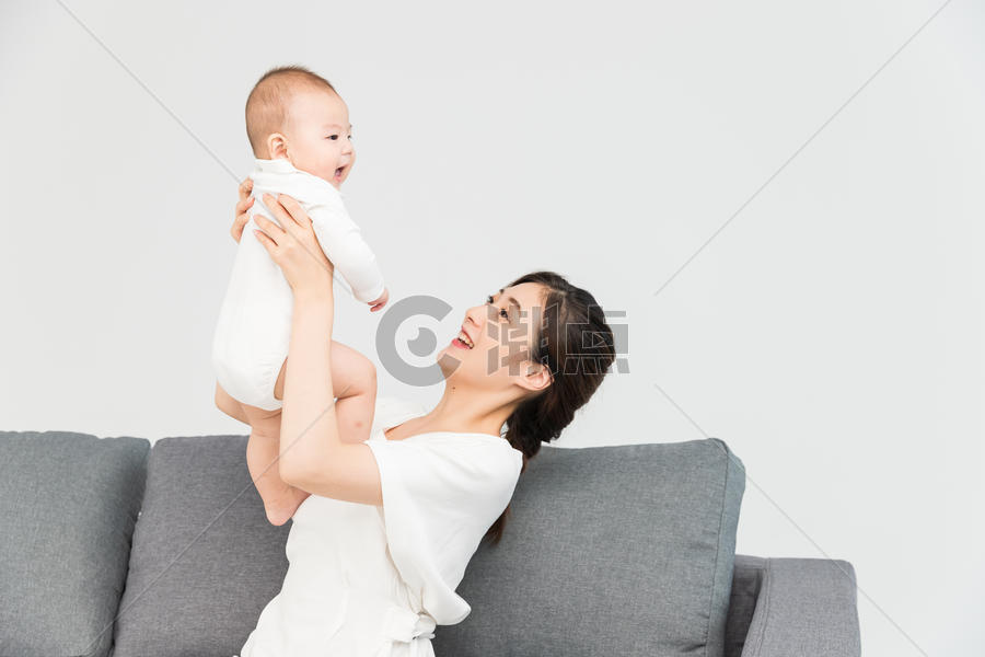 母婴沙发上妈妈举起宝宝图片素材免费下载