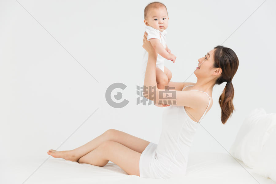 母婴床上妈妈举起宝宝图片素材免费下载
