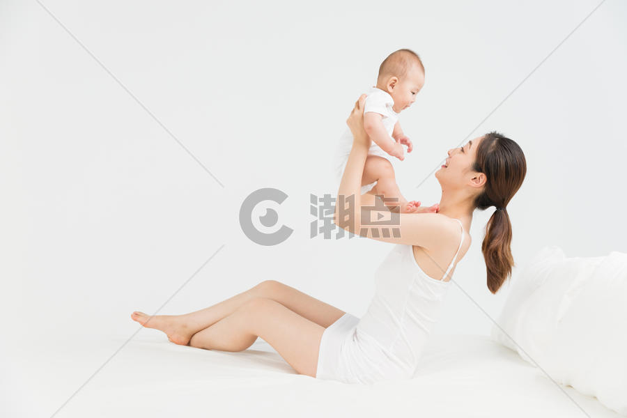 母婴床上妈妈举起宝宝图片素材免费下载