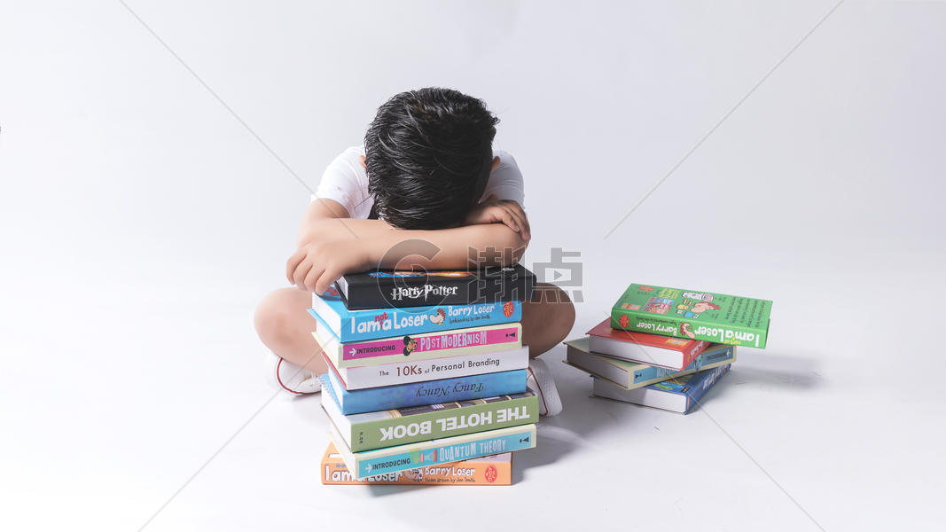 小孩子在书堆中疲劳困扰图片素材免费下载